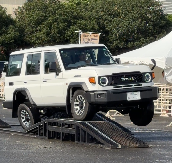land-cruiser-76-gdj76w-offroad トヨタ ランドクルーザー70 再再販モデルが試乗コースで片輪を浮かせながらデモ走行する様子。サスペンション性能を示すオフロード体験イベントの一場面